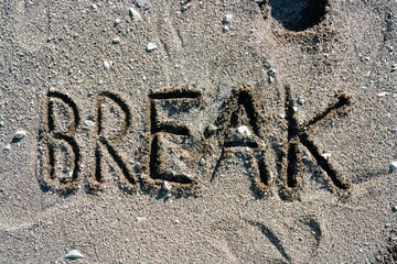 Break written in the dark rough sand