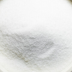 Overhead view of white sugar in a white bowl, top view of granulated sugar in a bowl