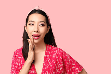 Beautiful Asian woman with stylish makeup on pink background