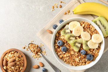 Tasty granola with fresh fruits on grey table, flat lay. Space for text