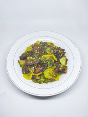 Jerado cabe hijau or Dendeng is a traditional cuisine from west sumatera, indonesia. it is made from slice of beef with spicy sauce called sambal. served on plate and isolated white background