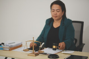 Pretty Asian female lawyer working and hammer, laptop, justice advice and legal concept. In office