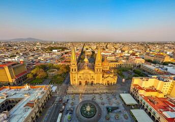 A panoramic aerial photo captures the stunning facade of Guadalajara's Cathedral at sunset. The...