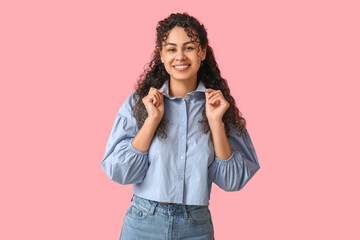 Beautiful young African-American woman in stylish blue collar shirt on pink background