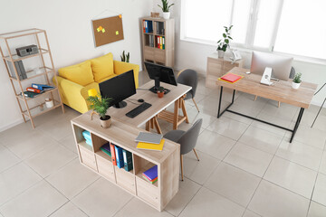 Interior of stylish office with modern workplaces and sofa