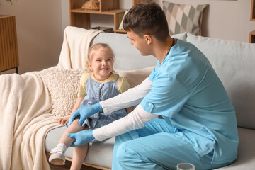 Male pediatrician examining little girl at home