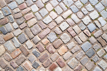 Background of bricks road. Background with bricks road. Stone cladding pavement. Brick surface background. Rough brick road. Stone pavement texture.