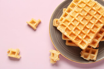 Plate with tasty Belgian waffles on pink background