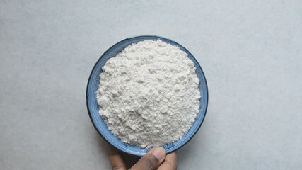 Overhead view of All purpose flour in a blue plate, baking flour in a plate on a marble countertop