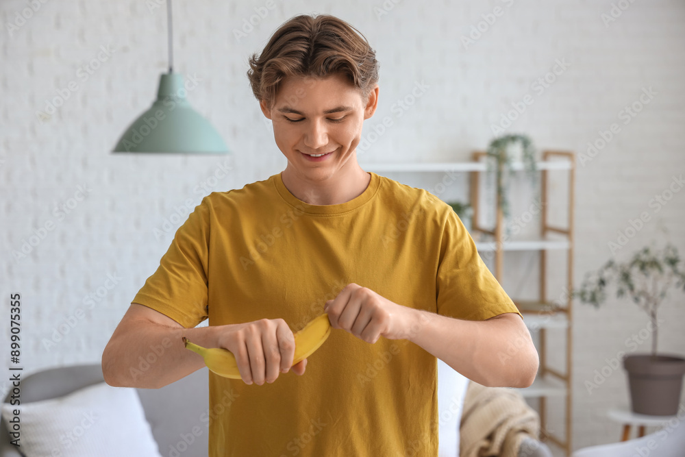 Poster Young man peeling banana at home