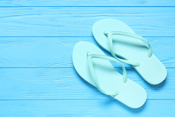 Beach flip-flops on blue wooden background