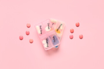 Plastic container with pills on pink background. Top view