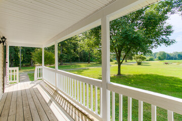 Fototapeta premium Charming Front Porch With Expansive Yard View And White Railing