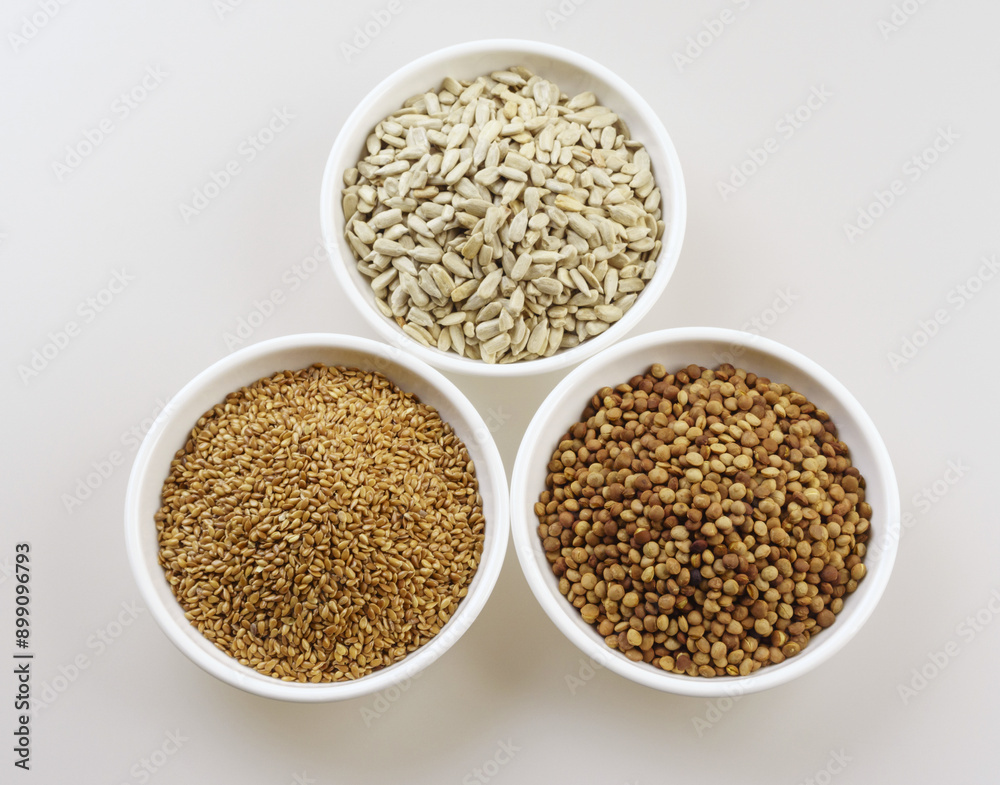 Sticker Close-up and top angle view of three bowls with dried grains of flax seed, lentils and sunflower seed, South Korea
