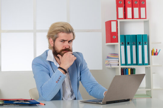 Serious Business man working with Stacks of paper files. Searching information. Report papers and piles of documents achieves on laptop computer desk in office. Male secretary working in office.