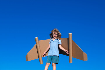 Naklejka premium Boy child with wings at sky imagines a pilot and dreams of flying.