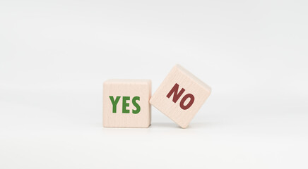 Make a mark and a cross x on the wooden cube. A wooden block with a green check mark and a red x contains a positive or negative decision.