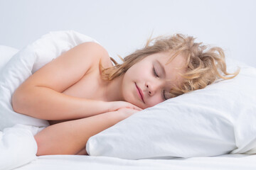 Fototapeta premium Kid sleeping in cozy white bed. Kid sleeping in bed. Child sleeping in bed under blanket. Kid lying on pillow, child rest asleep, enjoy healthy sleep or nap.