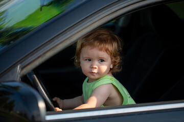 Child Driver. Baby in car with his hands on the wheel. Child Driver. Little kid driving car. Kid Are Sitting At The Wheel. Child playing with car. Dream, imagination, childhood. Kids Travel.