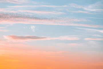 A beautiful sky tinted by the sun leaving vibrant shades of gold, pink, blue and multicolored. Clouds in the twilight evening and morning sky. Cloudy sky background in the evening and during the day.