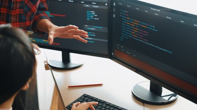 Slow motion back end or software developer manager supervising his team on new application program development on debugging and solving complex code algorithms on monitor. Burgeoning