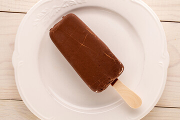 Chocolate ice cream on a ceramic plate, macro, top view.