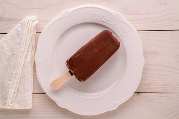 Chocolate ice cream on a ceramic plate, macro, top view.