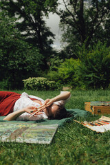 Female artis paints a picture in the park. Mindfulness, art therapy, creativity concept. Process of plein air painting in nature. A series of photos showing the step-by-step creation of a painting