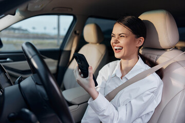 Woman, driver's seat, car, cell phone a woman, seated in the driver's seat of a car, holds a cell phone to her ear while looking directly at the camera, conveying communication and multitasking themes