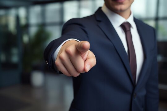 A professional in a business suit extends an authoritative finger, gesturing forward in a corporate environment.