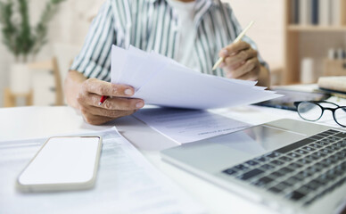 Asian man entrepreneur working at home checking about business document, report and business contract before start new business