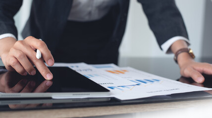 Business analyst using digital tablet analyzing financial statement, business report for audit internal control system. Businesswoman working with business documents at office