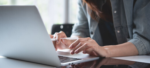 Close up, woman hand typing on laptop computer keyboard. Business woman online working on laptop...