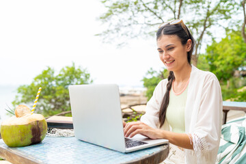 Caucasian woman freelance remote working online corporate business financial on laptop computer at beach cafe. People enjoy outdoor lifestyle travel tropical island on summer beach holiday vacation.