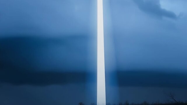 A solitary illuminated cross stands solemnly casting a powerful beam of light in the midst of a stormy foreboding sky.