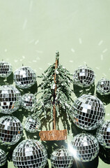 Multiple disco balls surrounding small artificial Christmas tree.