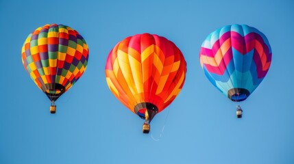 Obraz premium Three vibrant hot air balloons in a clear blue sky