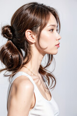 Side Profile of Beautiful Asian Model - Female with Perfect and Fine Features - Perfect and Glowing Skin - Looking up in Studio Environment - Styled and Smooth Hair - Fashion or Cosmetics Model