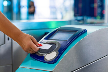 Applying a card at the turnstile in the Dubai metro. Women applying a card at the turnstile in the...
