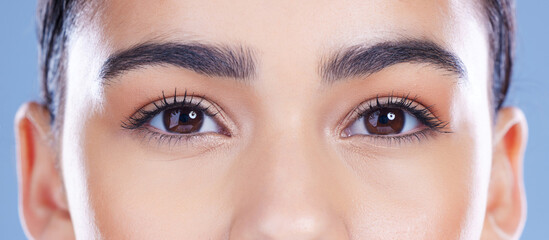 Optometry, vision and eyes of woman in studio with eyecare, optical exam or glaucoma assessment. Face, wellness and closeup of female person with eyesight health for ophthalmology by blue background. © Van Wyk/peopleimages.com