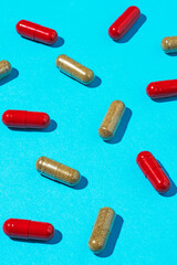 Red and brown capsule pills on blue background