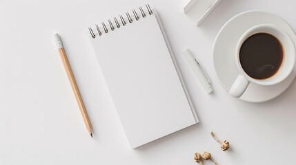 Flat lay of a simple writing setup with a white notepad, pencil, and coffee cup