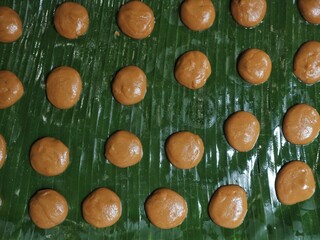 Ring cake dough made from brown sugar and rice is placed on banana leaves