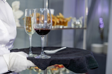Waiter service white wine and red wine on black slate platter