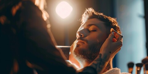 A masculine makeup artist applying makeup to a man, showcasing skillful techniques and a focus on enhancing masculine features