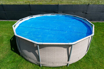 Large expansion pool with a diameter of 3.96 m, located in the yard on the grass, covered with a...