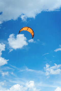 Orange kite in the blue sky.
