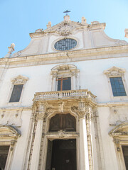 Baroque-style church facade with columns, ornate details, and a cross