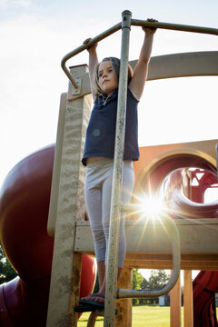 Young girl playing on playground equipment summer