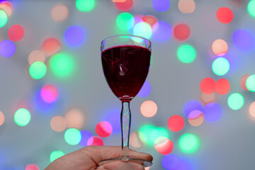 Kieliszek słodkiej nalewki między kolorowymi światełkami tworzącymi piękny bokeh 